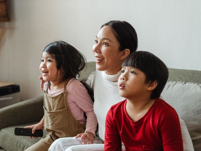 Woman and two children watching TV